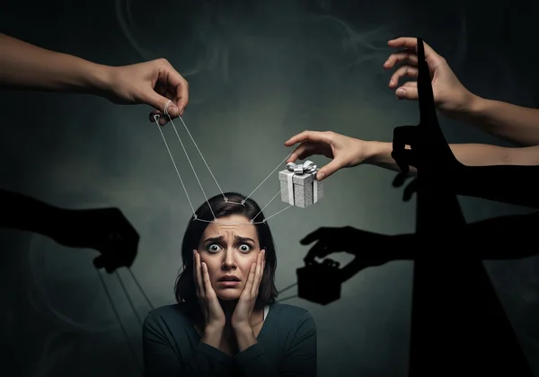 Hands manipulating a person with gaslighting tactics